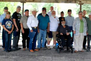These local vets were honored by Rep. Dusty Johnson. From the left, Dennis Baer, John Swede, Randy Shaw, Fred Wells, Nila Charles, Martin Scott, Larry Rogers, William Moldenhauer, Ed Humble, Charles Harrison, Arlan Emmert, Martin Anderson, Dave Baumiller, Andy Howie (seated), Miles Reed, the wife of Don Scheurenbrand, Andy Anderson, Peter Bonnichsen, Myan Charles, and Rep. Dusty Johnson. Photo by Betty Bruner